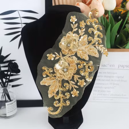 Guld spetsapplikation med paljetter och blommor