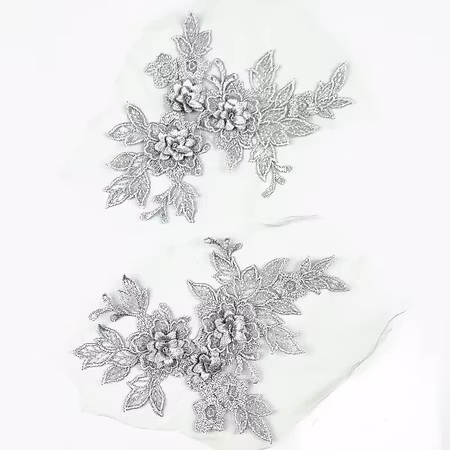 Spetsapplikation på mesh, spegelvänt par. Silver