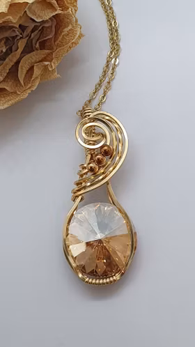 Halsband Swirly i mässing med Golden Shadow Swarovski kristall
