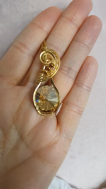 Halsband Swirly i mässing med Golden Shadow Swarovski kristall