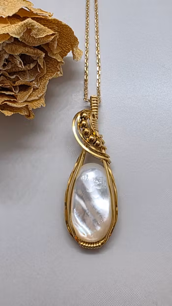 Halsband Swirly Pearls i mässing med vit pärlemor