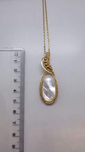 Halsband Swirly Pearls i mässing med vit pärlemor