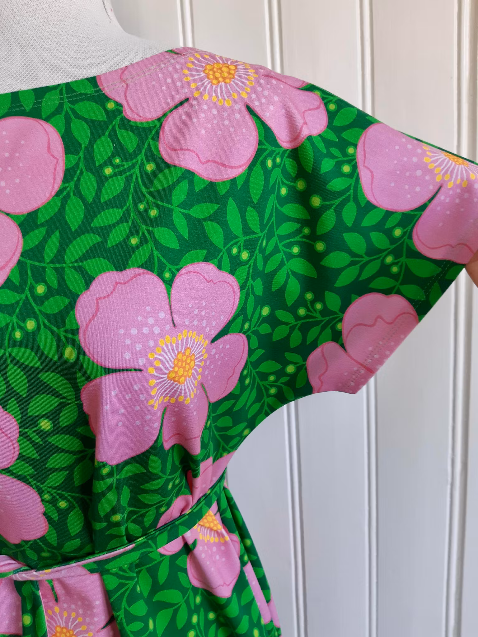 Rosa blommor och gröna blad