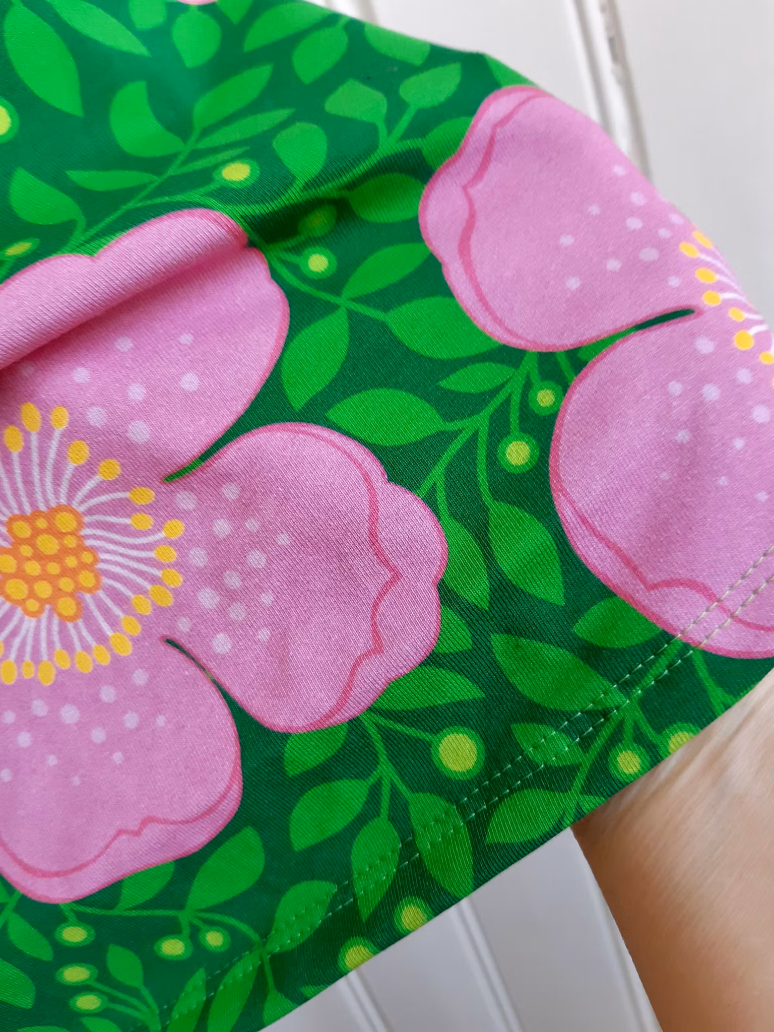 Rosa blommor och gröna blad