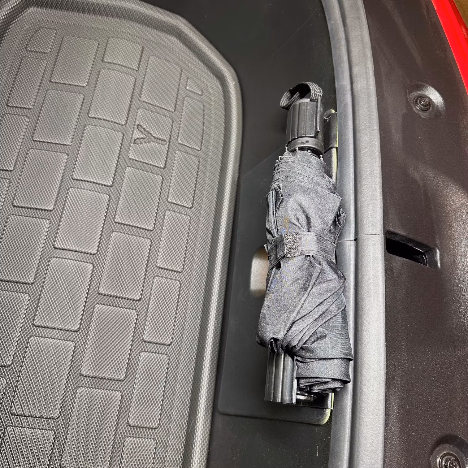 Smarta krokar som håller ett hopfällbart paraply på plats i frunken