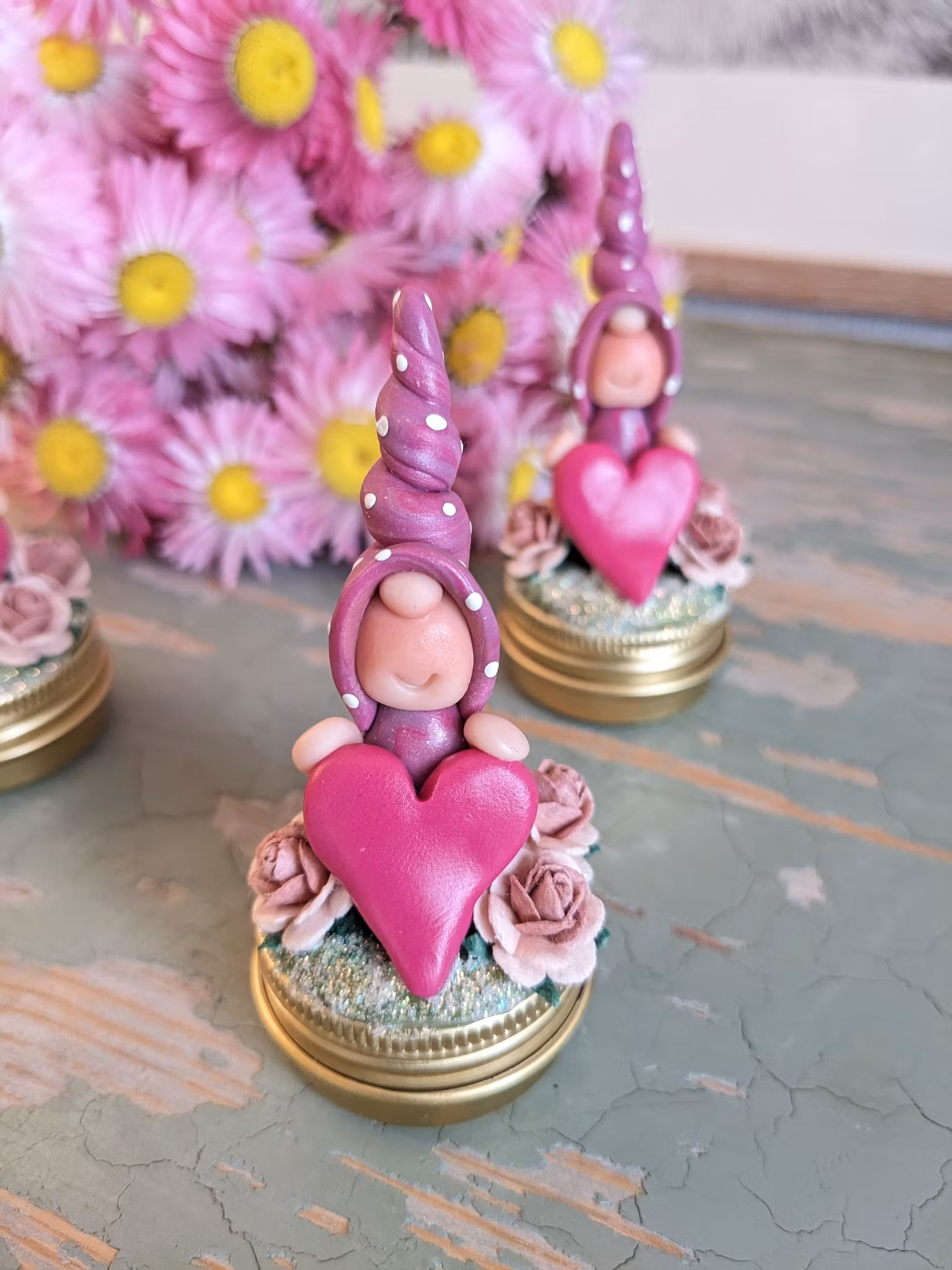 Liten guldfärgad burk med dekorationer på locket- Nisse med hjärta och rosor