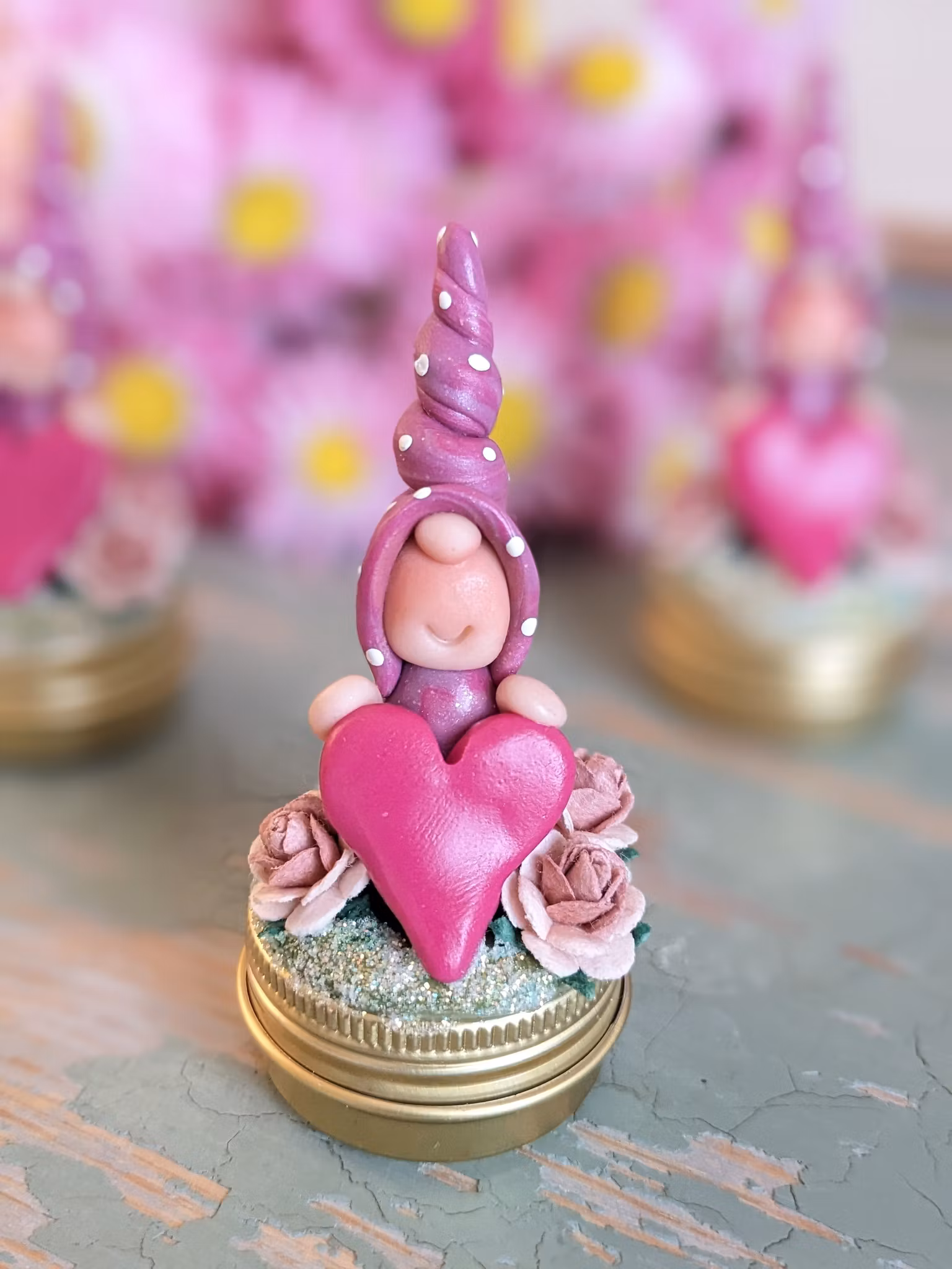 Liten guldfärgad burk med dekorationer på locket- Nisse med hjärta och rosor