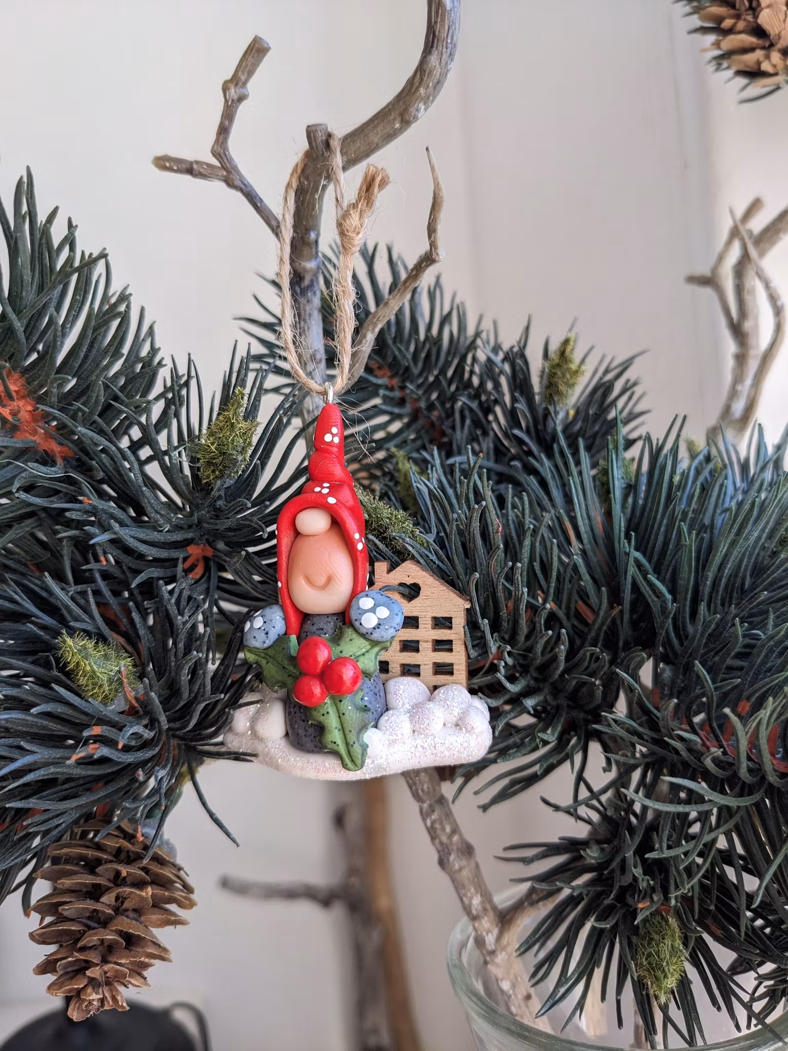 Julgranshänge- Nisse med julbär och söta trähus i bakgrunden