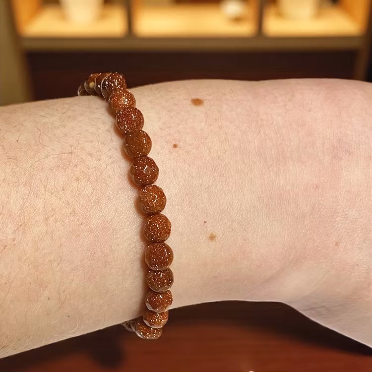 Sandsten "Goldstone" Röd 6mm pärlor (Fasetterad) Armband