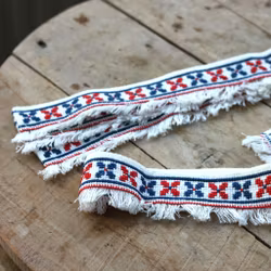 Hyllbård - Bård i rött och blått på vit väv.