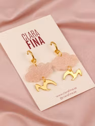 Vårtecken ljusrosa moln och guldfågel på ring