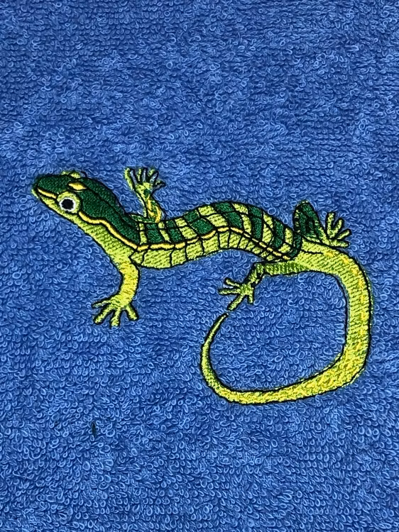 Blå badhandduk med en grön broderad ödla från Brodyrpalatset. Personlig handduk med namn och motiv.