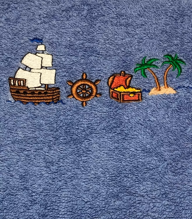 Handduk med namn. Pirat-tema broderad på en blå badhandduk från Brodyrpalatset.