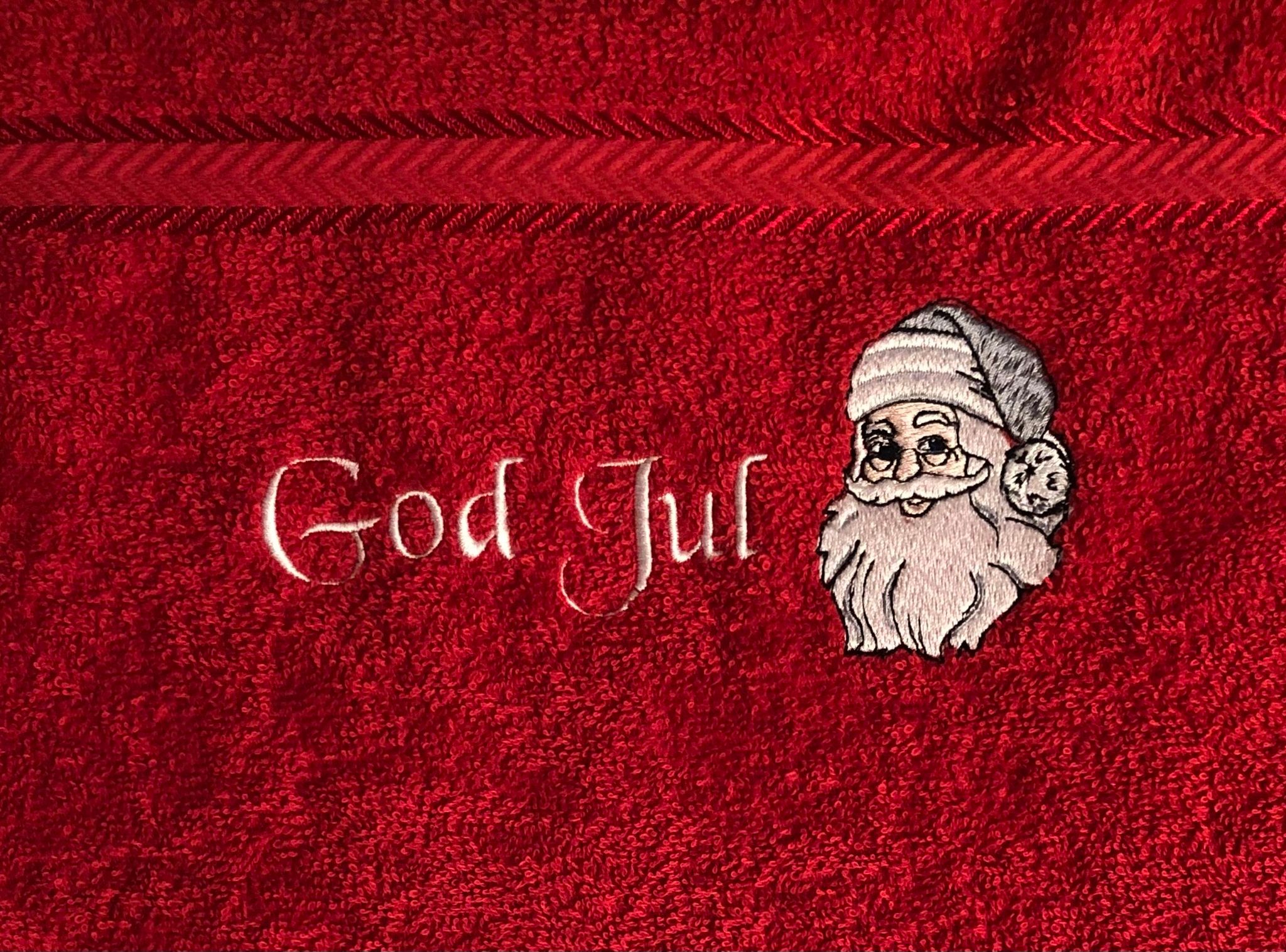 Gästhandduk julhandduk med en broderad tomte och texten Godjul på en röd frottéhandduk
