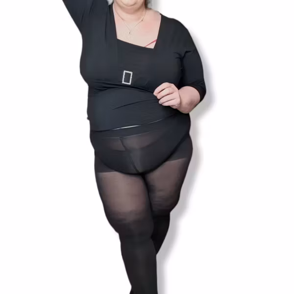 stående tjock kvinna med svarta strumpbyxor som har en shapingbyxa plus sze