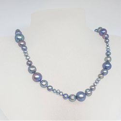 Halsband med blå pärlor i vågmönster