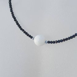 Halsband med svart spinell och vit agat slipad som golfboll