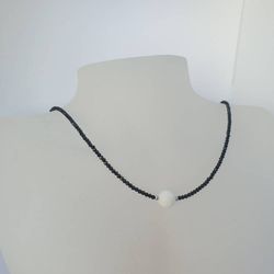 Halsband med svart spinell och vit agat slipad som golfboll
