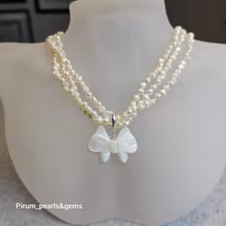 Halsband med tre rader vita pärlor och pärlemorhänge