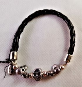 Armband i flätat läder med små dödskallar i metall