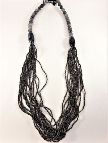 Långt halsband med stora och små pärlor i grått