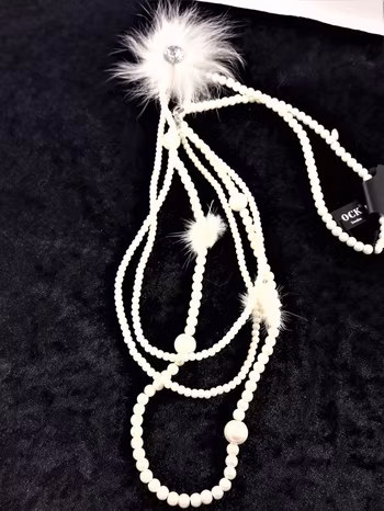 Långt vitt flerradigt halsband med kulor och detaljer i skinn