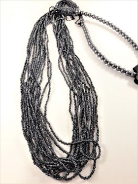 Långt halsband med stora och små pärlor i grått