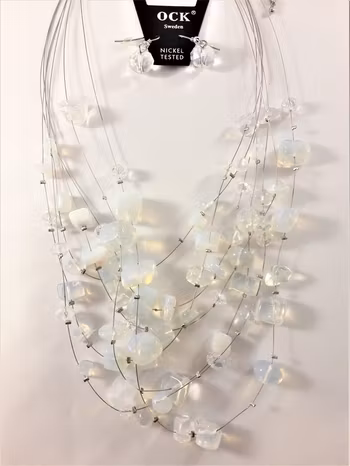 Flerradigt halsband med ljusblå-färgade dekorationer och matchande örhängen