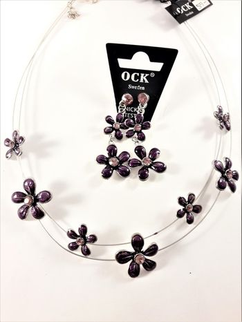 Halsband med lila blommor samt matchande örhängen
