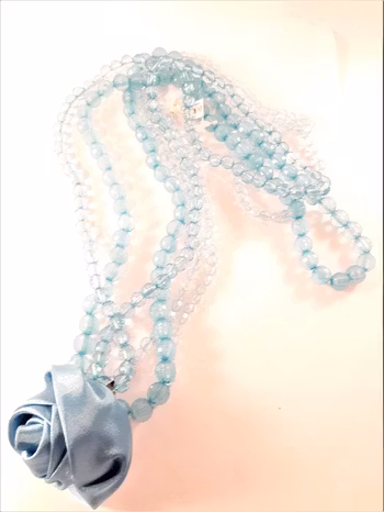 Halsband i blått med flerradiga plastpärlor och ros som dekoration