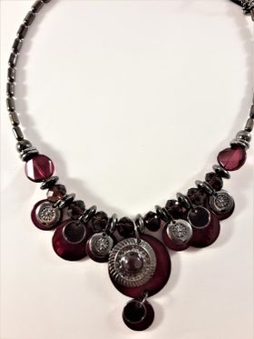 Detaljrikt halsband med många detaljer i lila och silverfärg