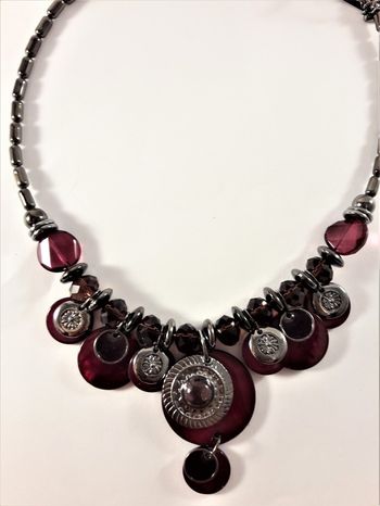Detaljrikt halsband med många detaljer i lila och silverfärg