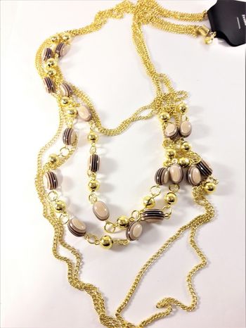 Flerradigt halsband med guldfärgade detaljer