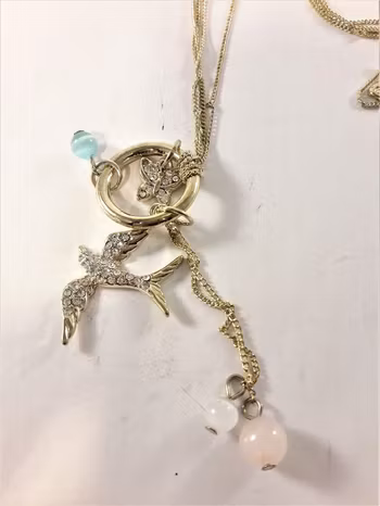 Halsband med kulor och strassprydd svala och fjäril guldfärg