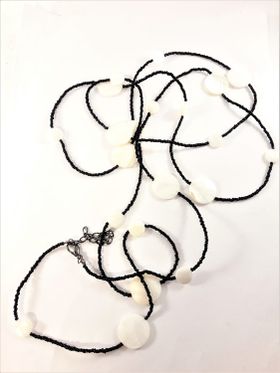 Långt halsband med svarta pärlor och vita snäckskal