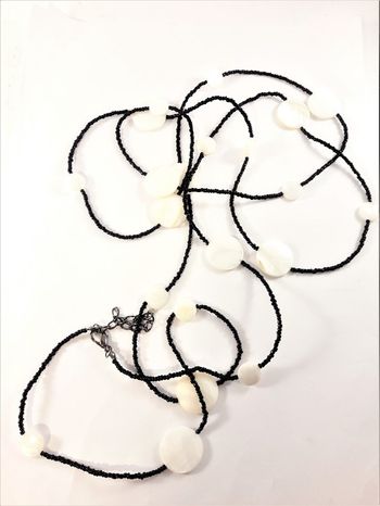 Långt halsband med svarta pärlor och vita snäckskal