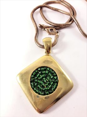 Halsband i guldfärg med hänge i grönt