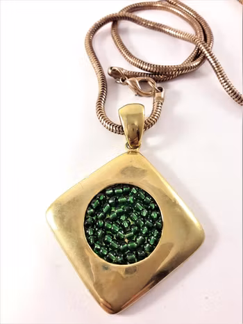 Halsband i guldfärg med hänge i grönt