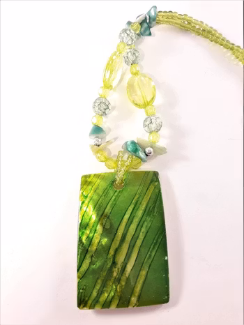 Halsband med gröna detaljer och snäckskal
