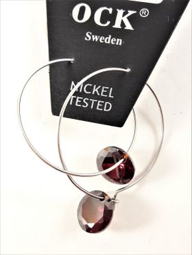 Örhängen med silverfärgad ring och röda detaljer
