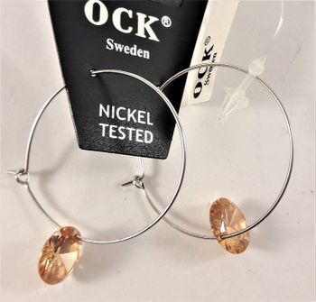 Örhängen med silverfärgad ring och gula detaljer