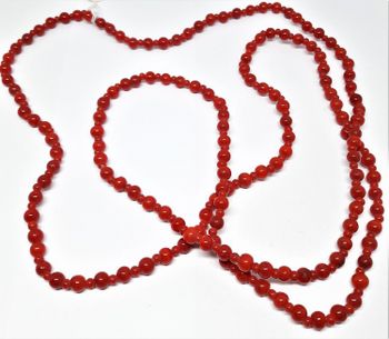 Långt halsband med små röda kulor