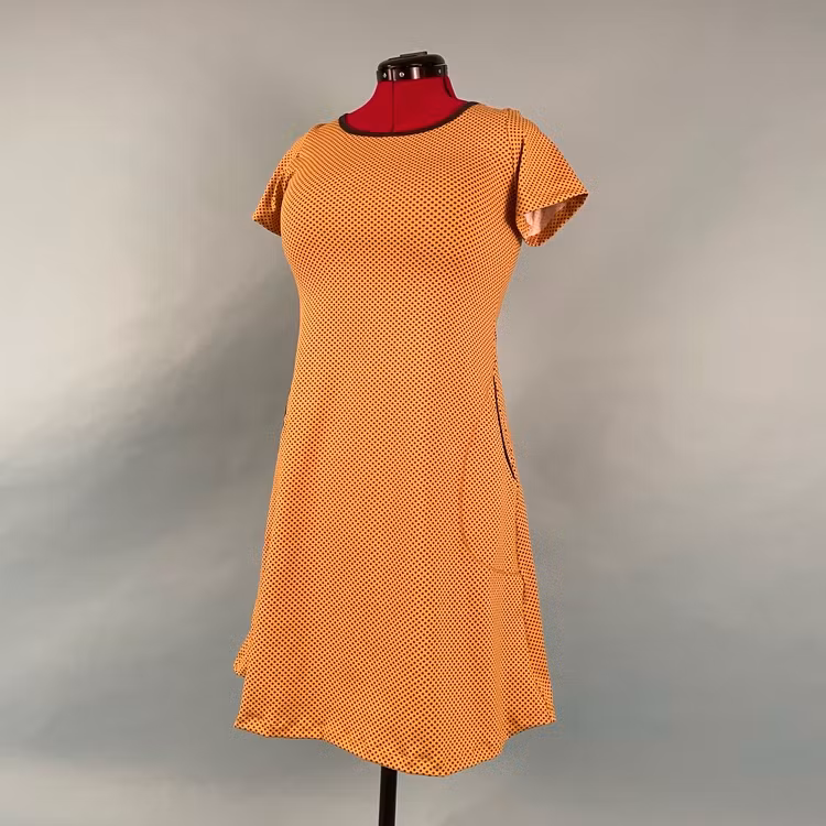 A-linjeformad trikåklänning i valfritt ekologiskt tyg, med valbar ärmlängd och fickor.