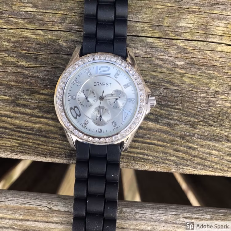 Svart klocka med blingbling och ljus urtavla