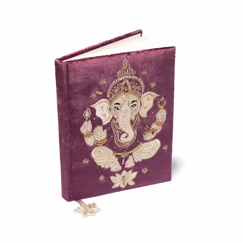 Linjerad skrivbok, lila/vinröd med motiv av Ganesha på framsidan.