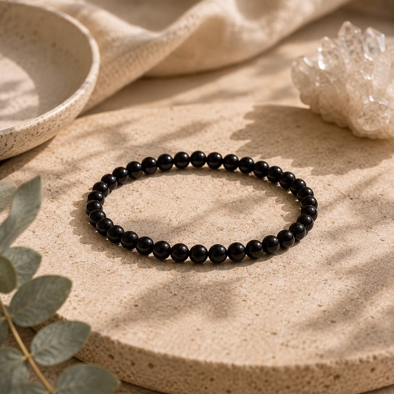 armband med runda pärlor av svart turmalin, pärlorna är ca 4 mm i diameter