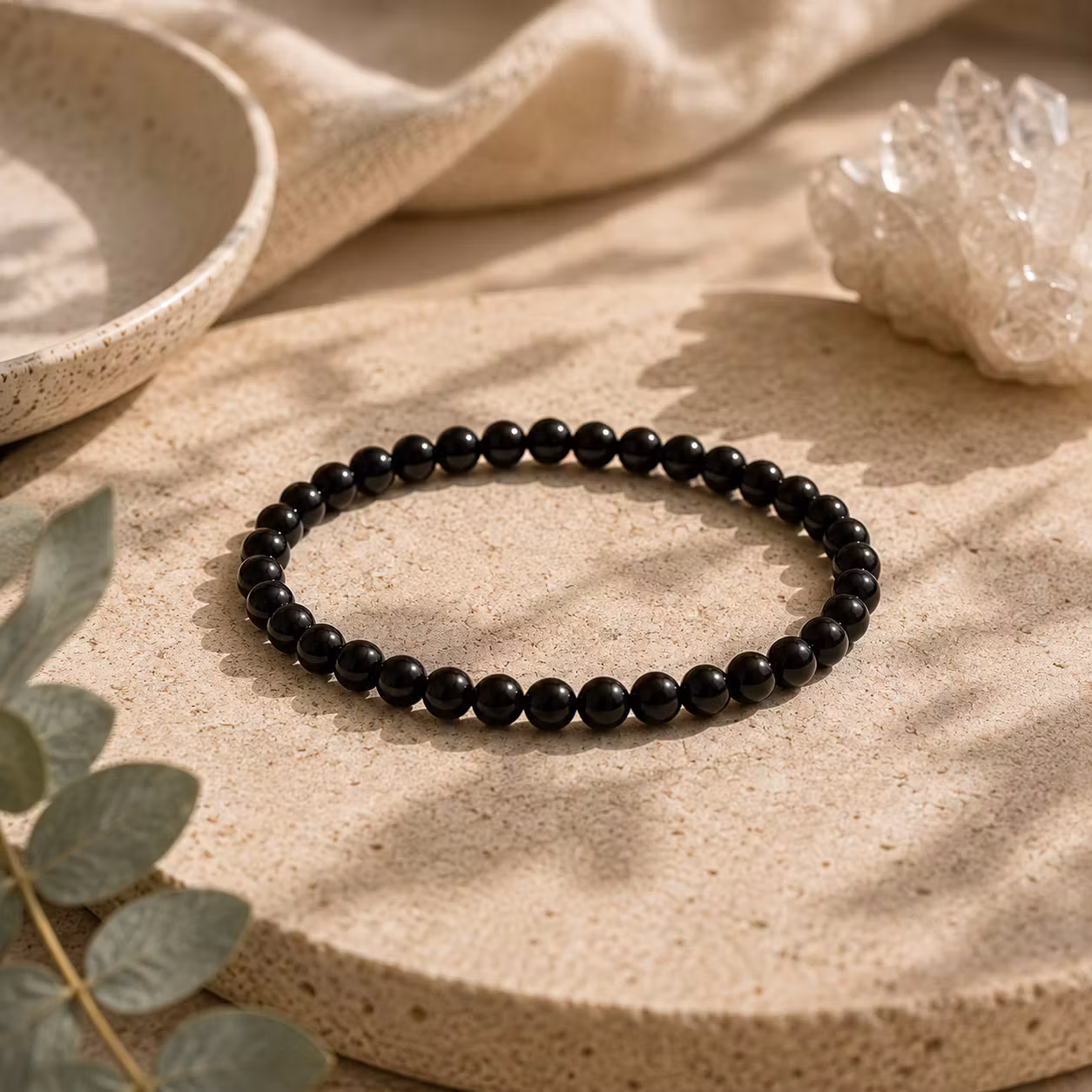 armband med pärlor av svart turmalin, pärlorna är ca 4 mm i diameter.