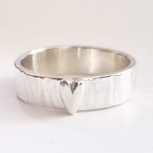 Medium-wide hammered silver ring with a silver heart