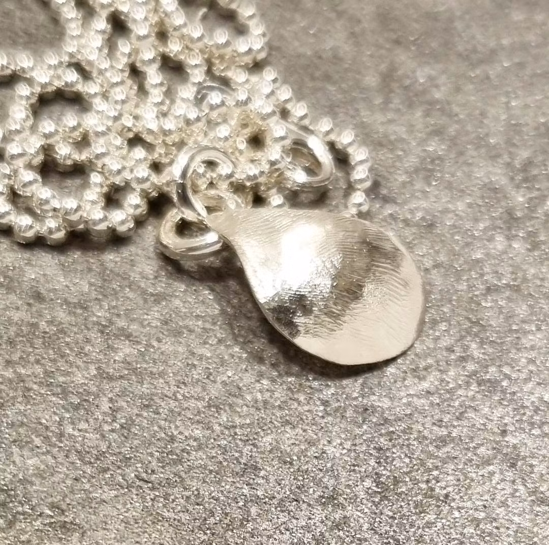 Silverhalsband med handsmidd stiliserad blåmussla med pärla