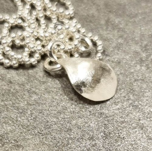 Silverhalsband med handsmidd stiliserad blåmussla med pärla